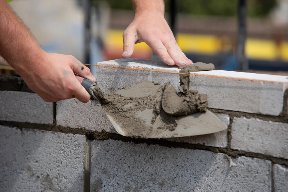 Chantier de rénovation extérieure d'un bâtiment résidentiel avec ouvriers sur échafaudage métallique