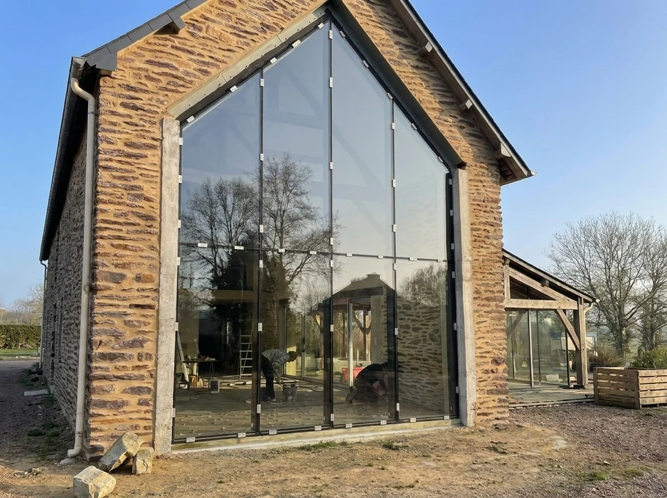 Extension moderne accolée à une maison en pierre ancienne