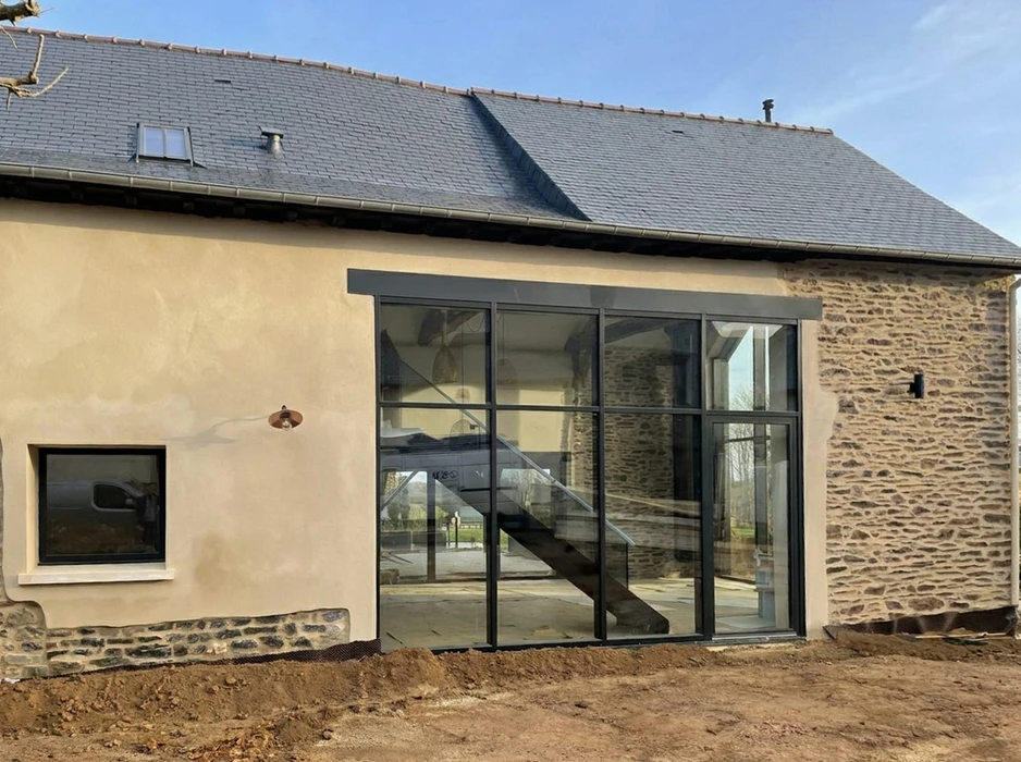 Façade arrière d'une maison bourgeoise rénovée, extension vitrée au rez-de-chaussée donnant sur une terrasse
