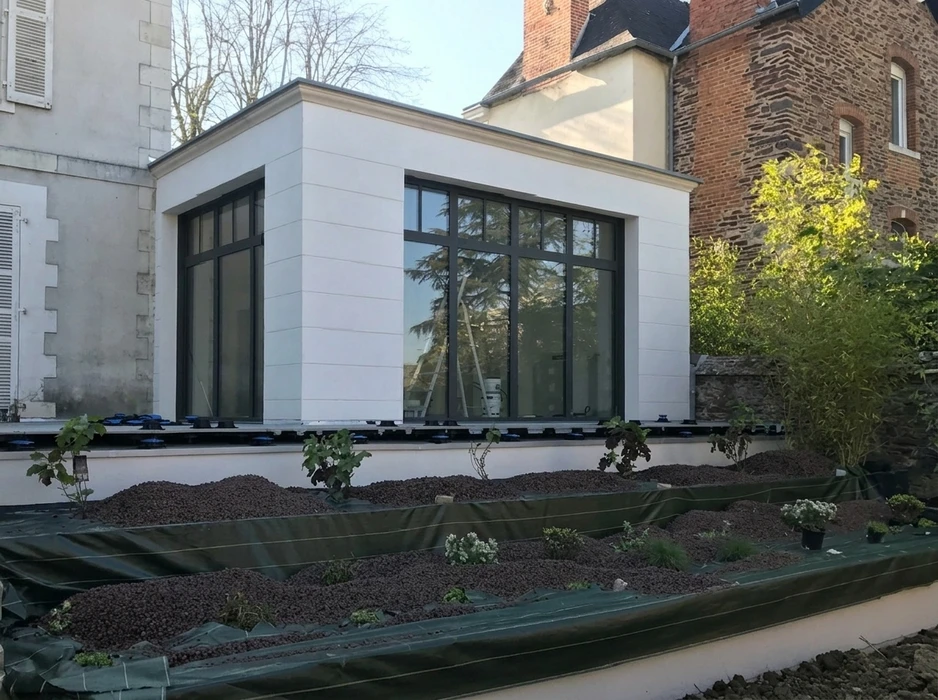 Terrasse surélevée en béton enduit gris avec escalier d'accès central
