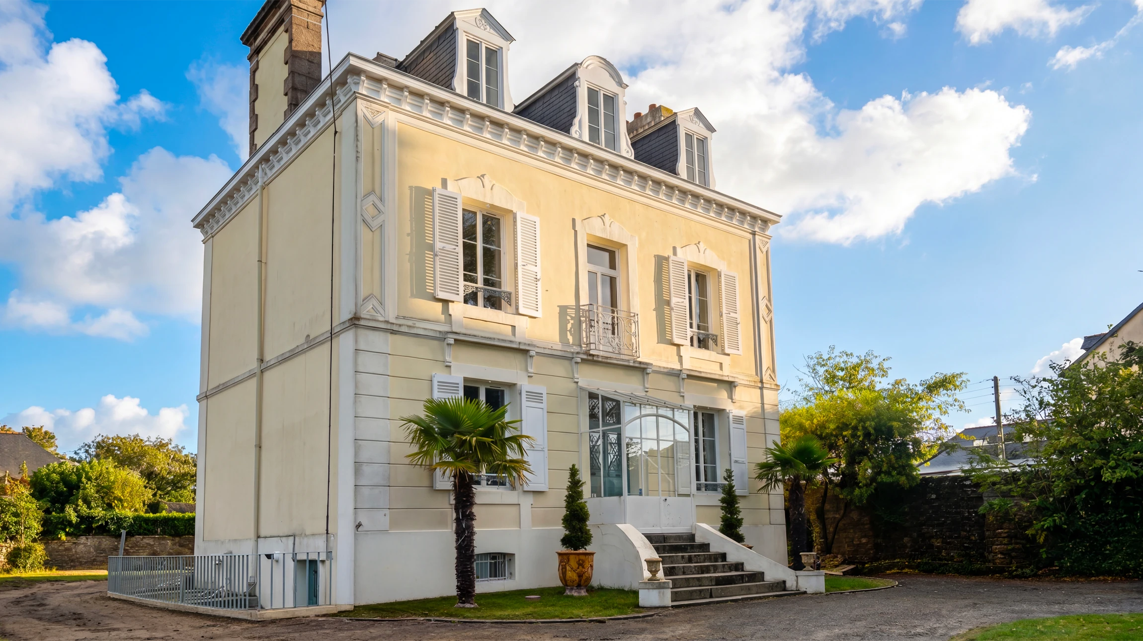 Deux ouvriers en bâtiment travaillent sur échafaudage, appliquant un enduit mural extérieur à la main